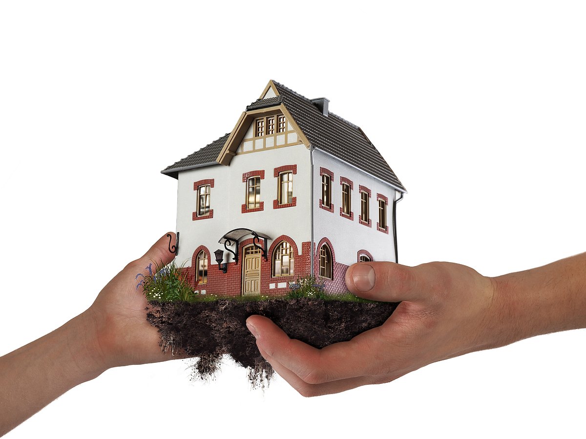 Two hands are holding the mini house