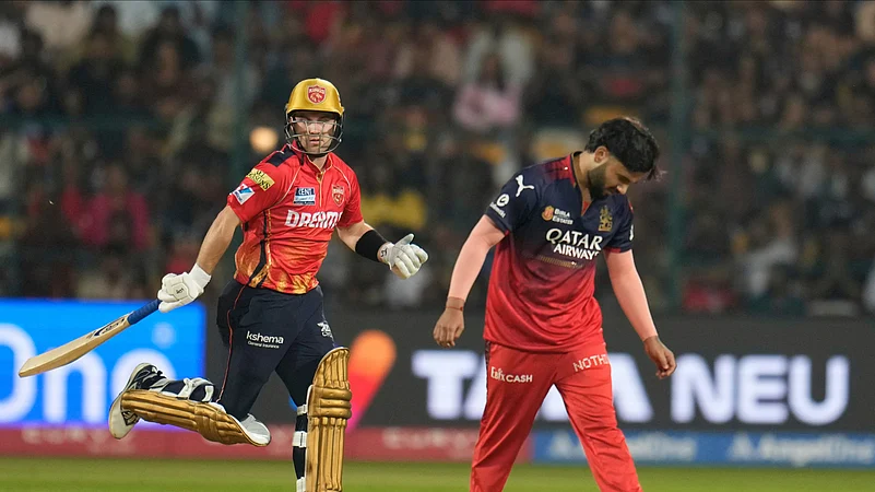 Punjab Kings Josh Inglis takes a run as RCBs Suyash Sharma reacts. AP