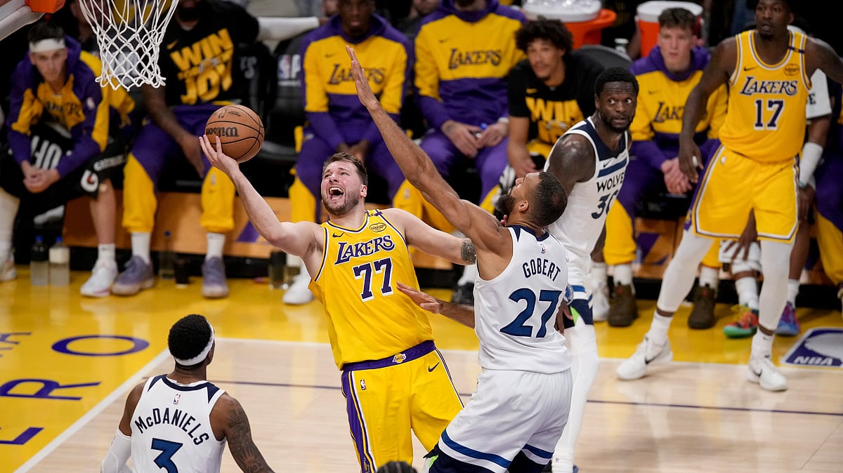 AP Photo/Eric Thayer : Los Angeles Lakers guard Luka Doncic (77) goes to the basket against Minnesota Timberwolves center Rudy Gobert (27) and forward Jaden McDaniels (3) during the second half of Game 2 of an NBA basketball first-round playoff in Los Angeles.