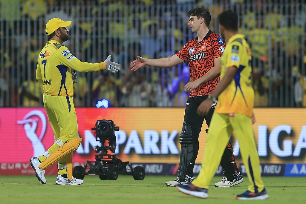 Mahendra Singh Dhoni, left, greets Pat Cummins