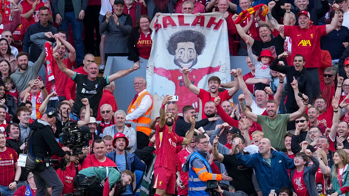 Liverpool's Mohamed Salah takes a selfie with a fan's smartphone as he celebrates after scoring his side's fourth goal during the English Premier League soccer match between Liverpool and Tottenham Hotspur at Anfield in Liverpool. - AP Photo/Jon Super