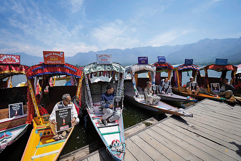 | Photo: AP : In Solidarity: Kashmiri boatmen hold placards to condemn the Pahalgam terror attack in Dal Lake, Srinagar