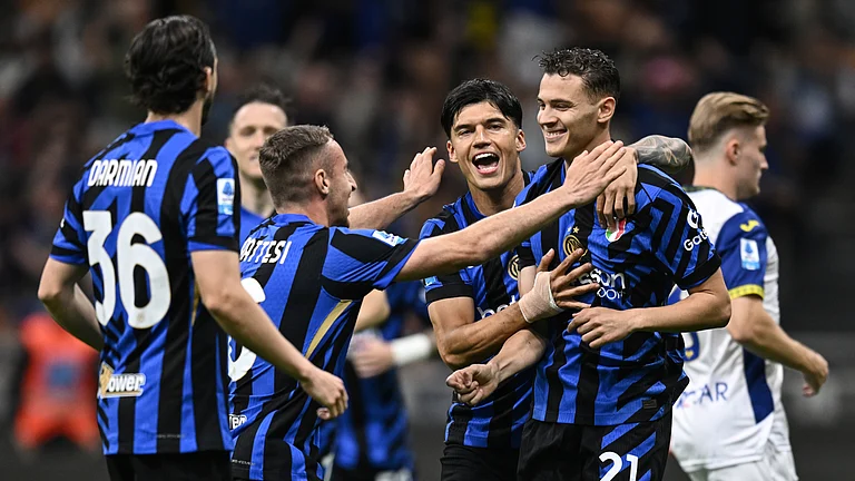 Kristjan Asllani is mobbed by his team-mates after scoring from the penalty spot - null