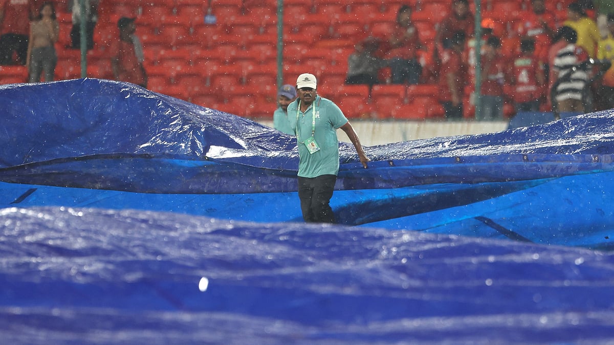 Groundstaff ready the covers in Hyderabad.