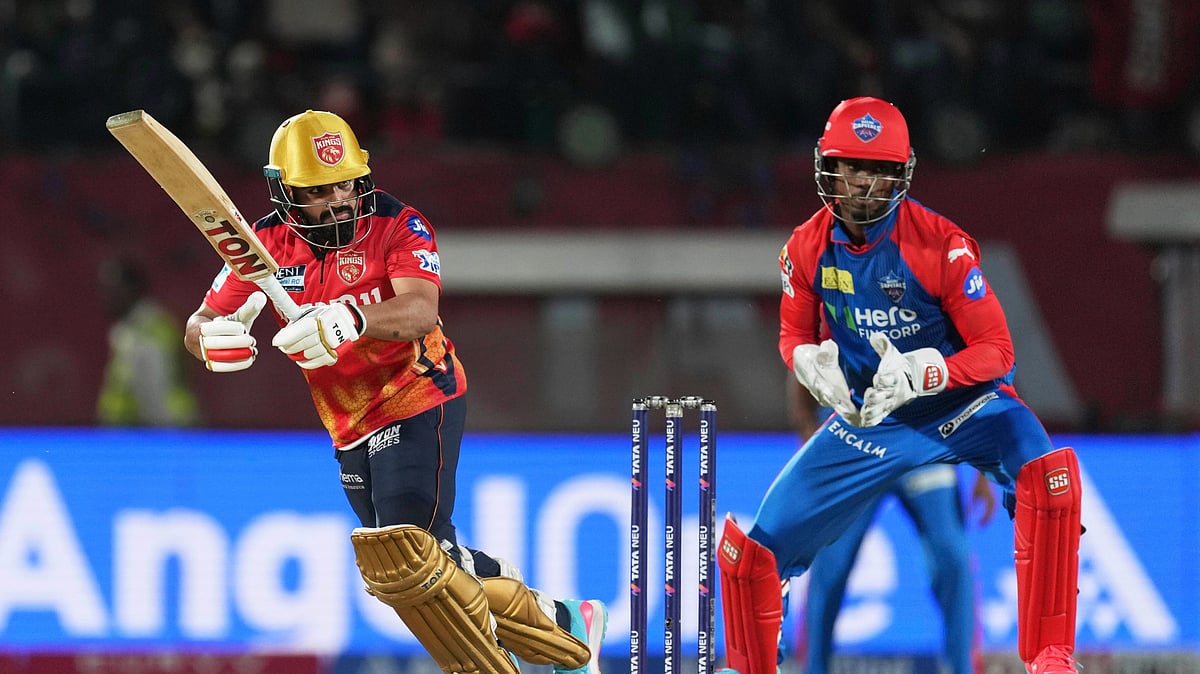 AP Photo/Ashwini Bhatia : Punjab Kings' Prabhsimran Singh, left, bats during the Indian Premier League cricket match in Dharamshala.