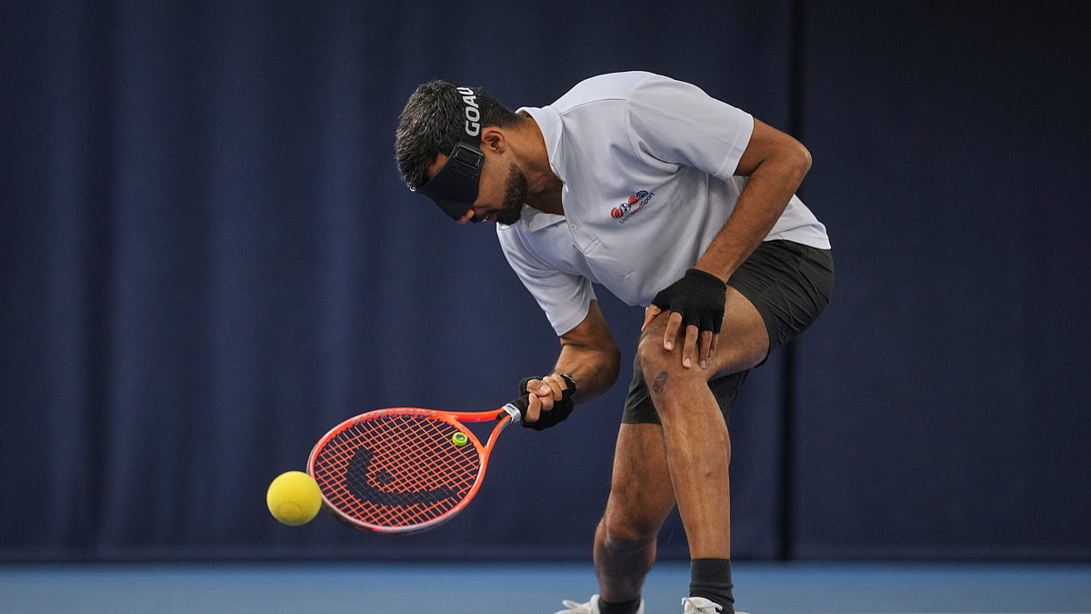 (AP Photo/Kin Cheung) : Blind tennis champion Naqi Rizvi plays a shot during a visually impaired tennis training session in London, Tuesday, May 20, 2025.