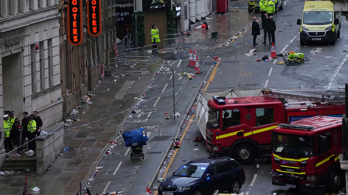 Fans leave as Police and emergency personnel deal with an incident after a car collided with pedestrians near the Liver Building during the Premier League winners parade in Liverpool, England, Monday, May 26, 2025. - (AP Photo/Jon Super)

