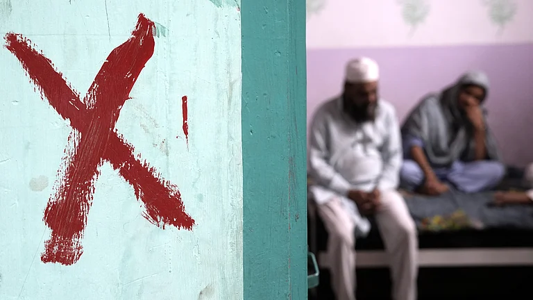 Family sitting inside a house marked with a red cross in Khasra No 277, Batla House, Okhla. - | Tribhuvan Tiwari |