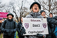 Higher Education Showdown: Trump vs Ivies Photo: Getty Images : ‘Educate, Don’t Capitulate!’: A Cambridge protester urging Harvard to resist Trump’s influence on the institution