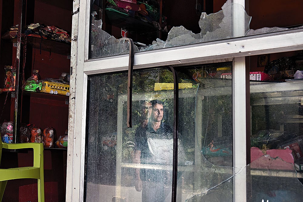 A man inside his damaged shop in Poonch town 