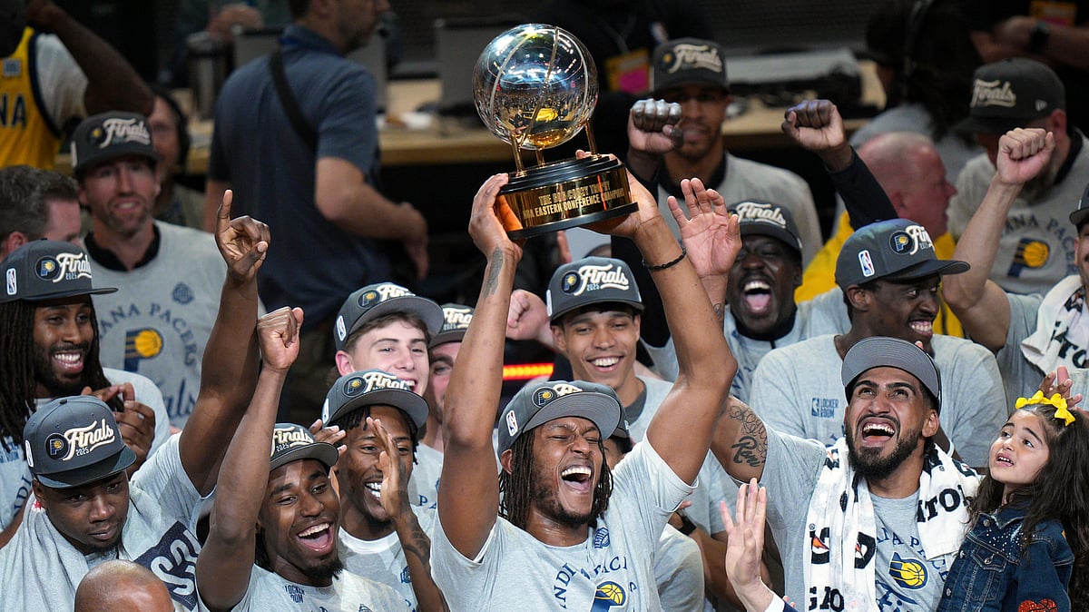  (AP Photo/AJ Mast) : Indiana Pacers center Myles Turner holds the trophy as players celebrate after winning Game 6 of the Eastern Conference finals of the NBA basketball playoffs against the New York Knicks in Indianapolis, Saturday, May 31, 2025.

