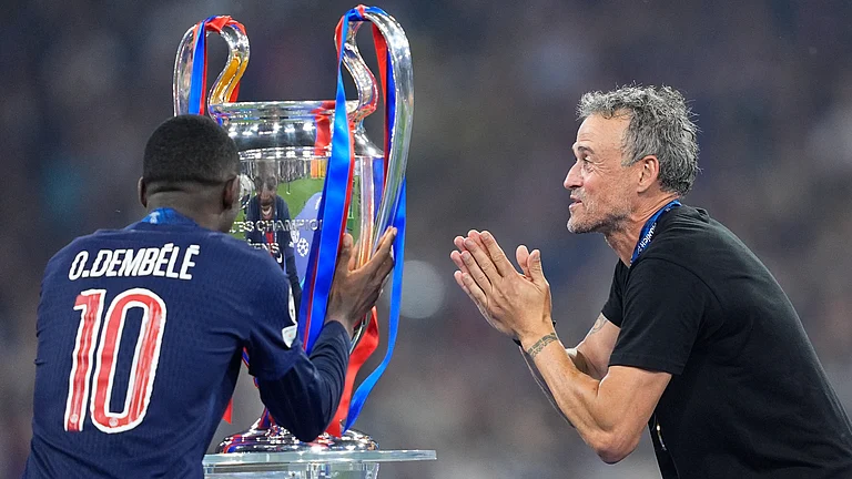 Ousmane Dembele kisses the Champions League trophy in front of Luis Enrique. - File