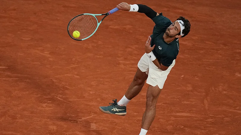 Italys Lorenzo Musetti serves against Denmarks Holger Rune. AP