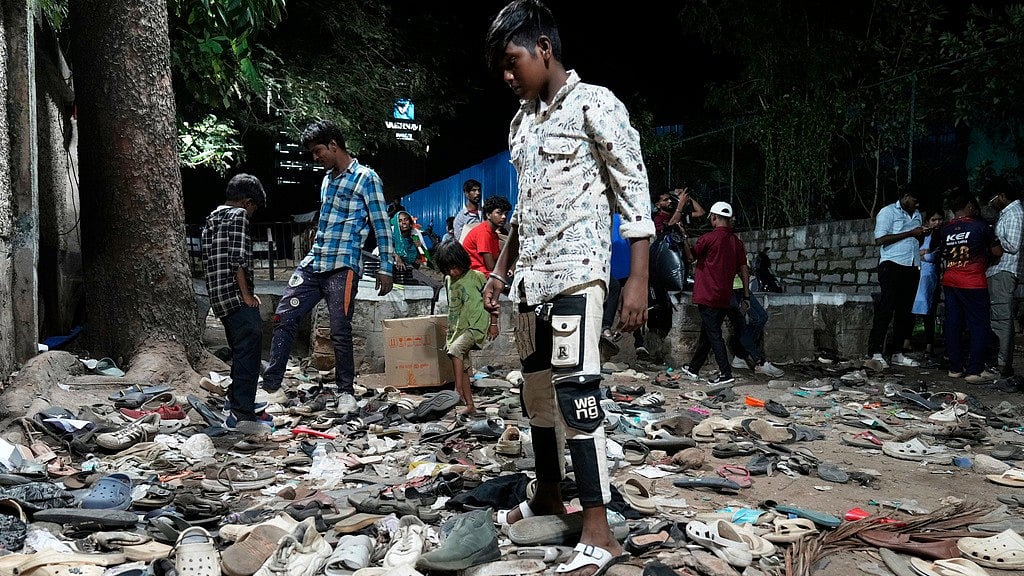 People rummage through footwear strewn outside M. Chinnaswamy Stadium