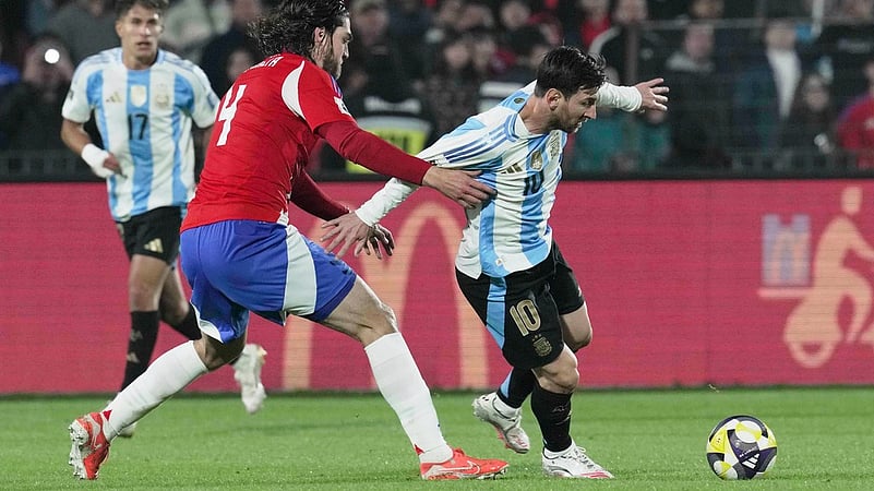 Argentinas Lionel Messi, right, and Chiles Francisco Sierralta battle for the ball