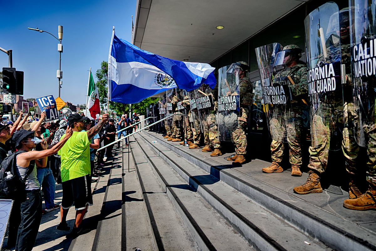 AP Photo/Eric Thayer : A protester waves a National Flag of El Salvador in front of a line of California National Guard in front of Federal Building on Monday, June 9, 2025, in downtown Los Angeles. 
