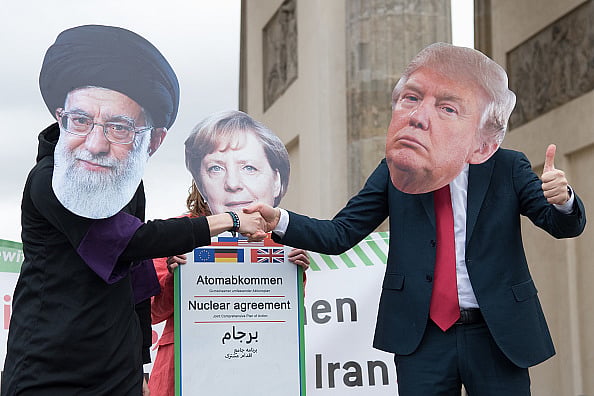  Jörg Carstensen/dpa (Photo by Jörg Carstensen/picture alliance via Getty Images : 11 January 2020, Berlin: Actors dressed as religious leaders Ali Chamenei (l-r), Angela Merkel and Donald Trump perform a street theatre action as part of an anti-war demonstration. About 200 people demonstrate against a war between Iran and the USA. 