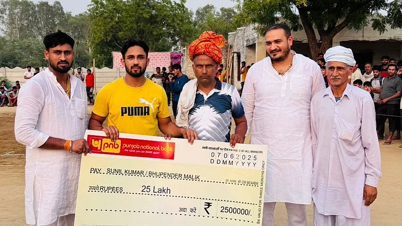 Sunil Kumar presents cheque to his childhood kabaddi coach