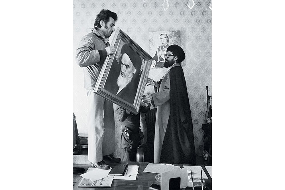 Palace employees replace a portrait of Shah Reza Pahlavi with one of Ayatollah Khomeini