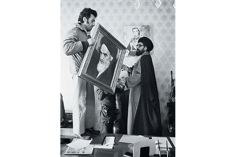 Palace employees replace a portrait of Shah Reza Pahlavi with one of Ayatollah Khomeini