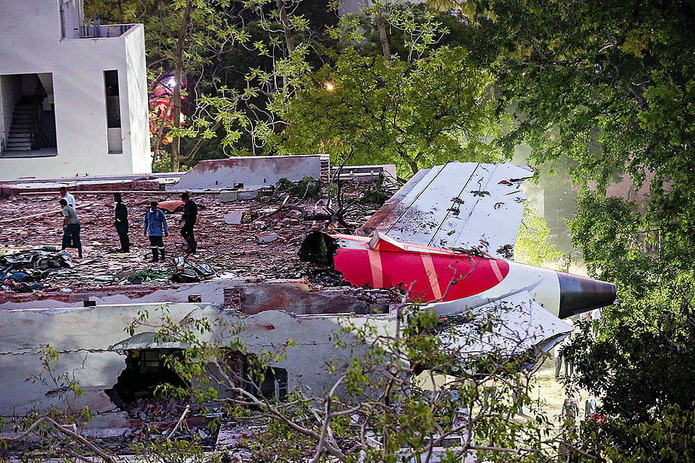 Mangled Remains: The tail end of the crashed Air India flight. The plane first fell on the canteen for medical students - | Photo: PTI