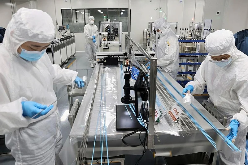 Workers labour at a manufacturer of medical polymer precision catheters