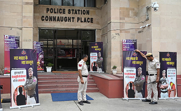 Photo by Sonu Mehta/Hindustan Times via Getty Images : Police install posters about the new criminal laws put up outside Parliament Street Police Station in New Delhi
