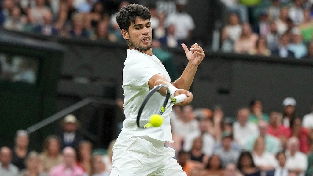 Photo: AP : Spain's Carlos Alcaraz returns to Russia's Andrey Rublev during a fourth round men's singles match at the Wimbledon Tennis Championships in London.