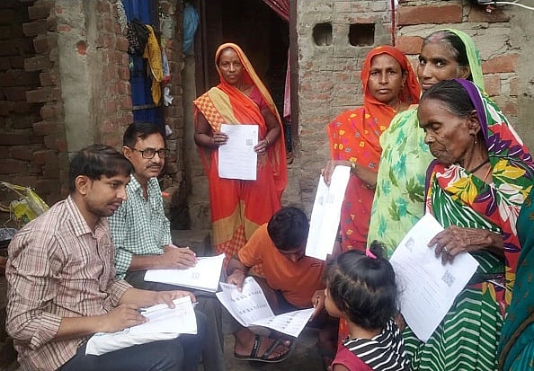 (Photo by Santosh Kumar/Hindustan Times via Getty Images)
 : Villagers filling forms during door to door distribution of Enumeration Forms on July 5, 2025 in Patna, India. 