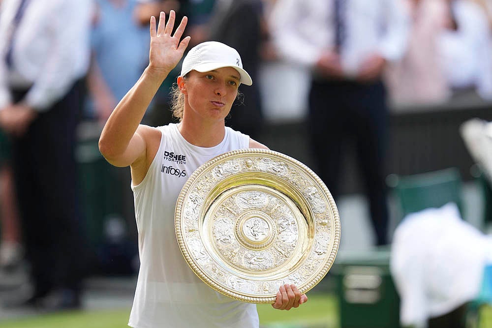 | Photo: AP/Kirsty Wigglesworth : Wimbledon 2025 Final: Iga Swiatek celebrates with the trophy