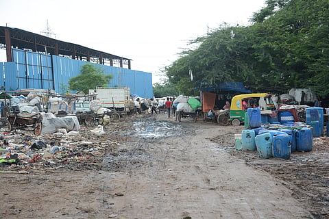 Water drums lay in mud at the Camp's main area