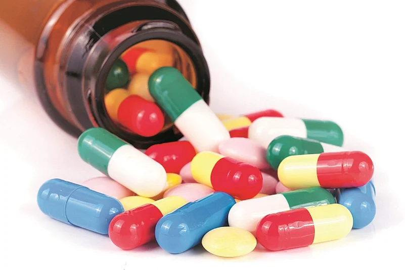 A bottle of capsules open and spilling capsules
