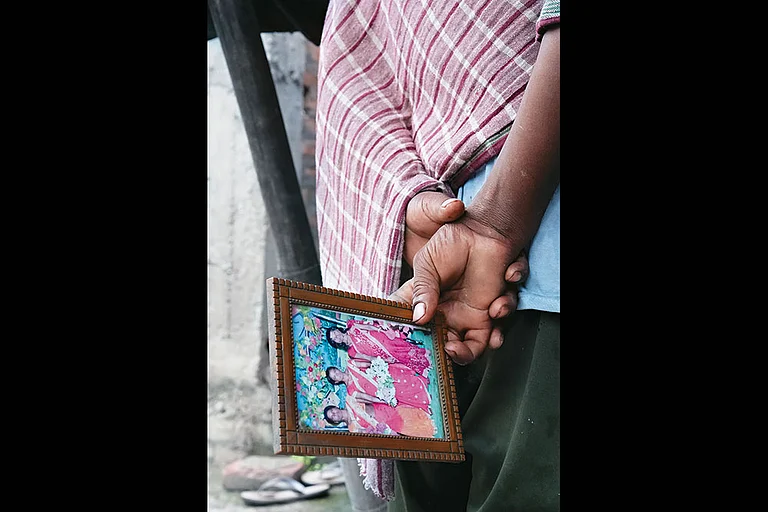 In Mourning: A relative carries a photo of one of his family members who was branded a witch and killed at Tetgama on July 6, 2025 - | Photo: Tribhuvan Tiwari