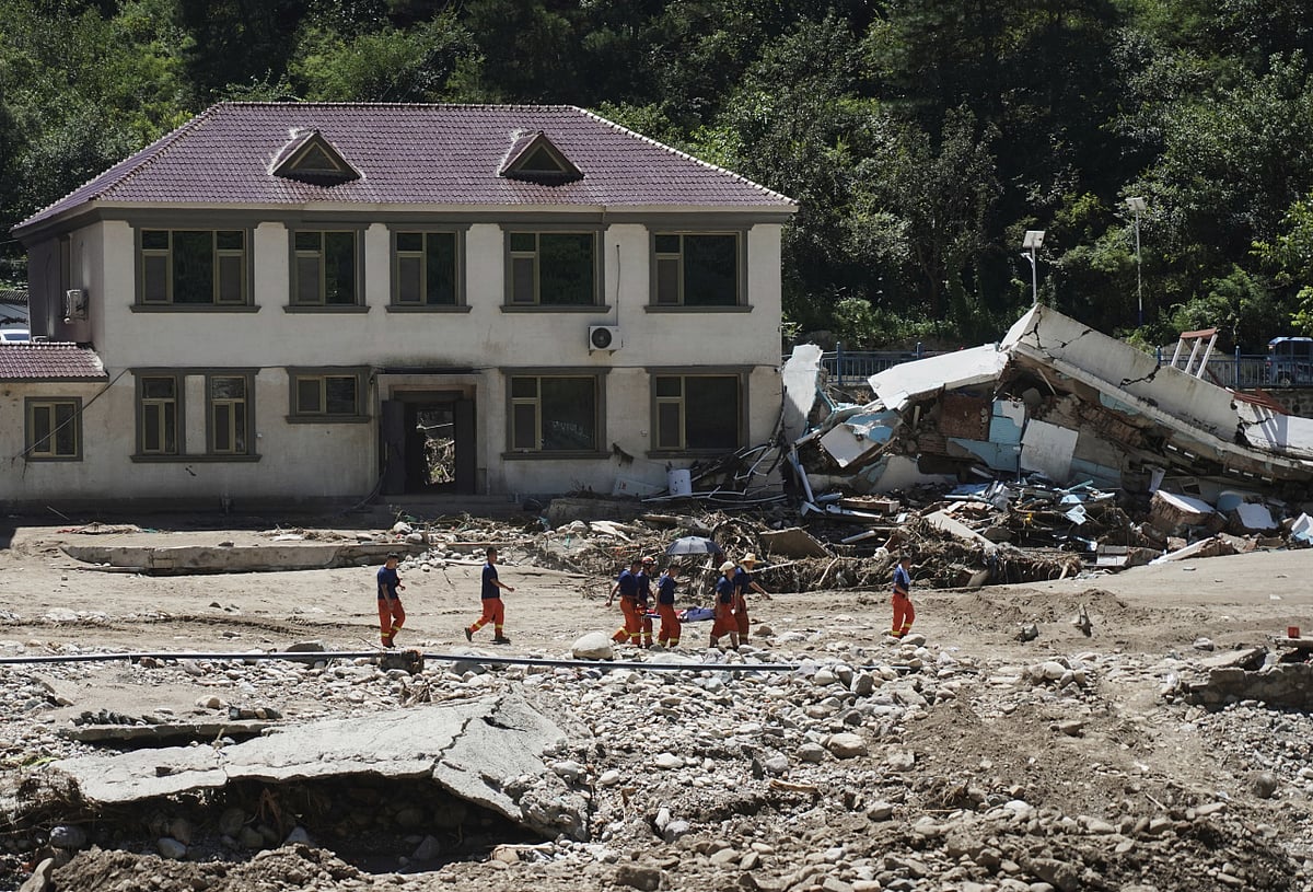 Xinhua News Agency : rescuers evacuate a stranded villager, passing an area damaged by floods after heavy rains in Liulimiao Town of Huairou District on the outskirts of Beijing on Wednesday