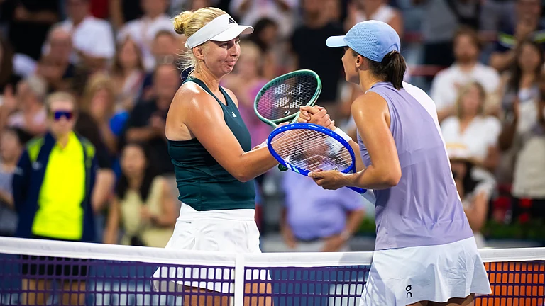 Clara Tauson shakes hands with Iga Swiatek after securing her win in the Canadian Open 2025. - null