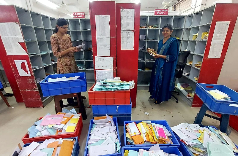 Postal worker sorting mail.