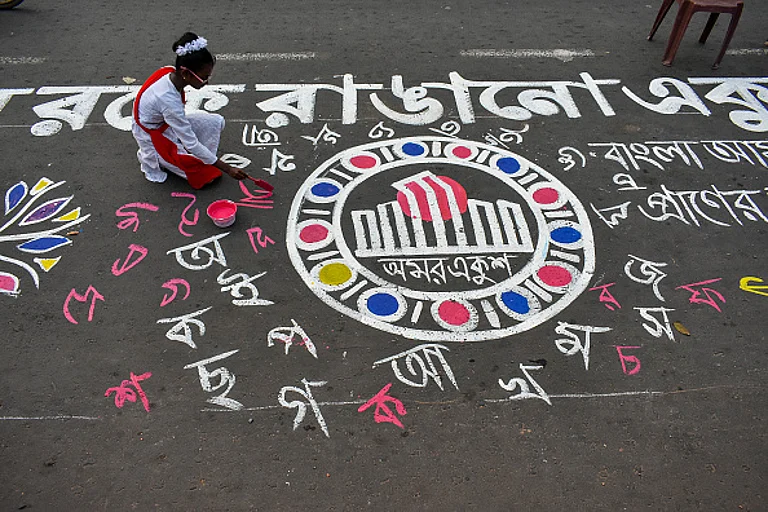 A girl is drawing various Bengali alphabets on the street in preparation for the International Mother Language Day celebration in Kolkata, India, on February 20, 2024. - Debarchan Chatterjee/NurPhoto via Getty Images