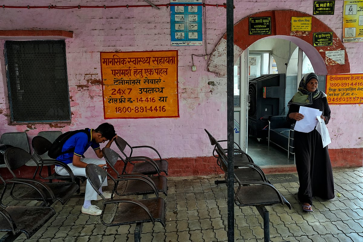 A woman standing beside a mental health centre advertisement 
