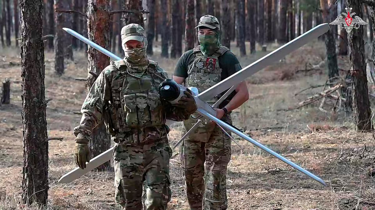 AP : In this photo taken from video distributed by Russian Defense Ministry Press Service on Thursday, Aug. 14, 2025, Russian soldiers carry a Lancet drone in an undisclosed location in Ukraine.
