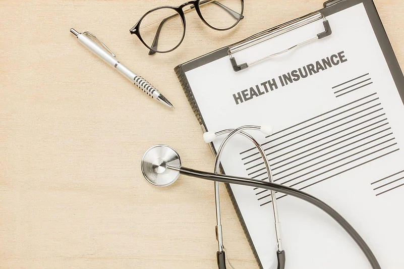 Health insurance document with stethoscope, pen, and glasses on a desk