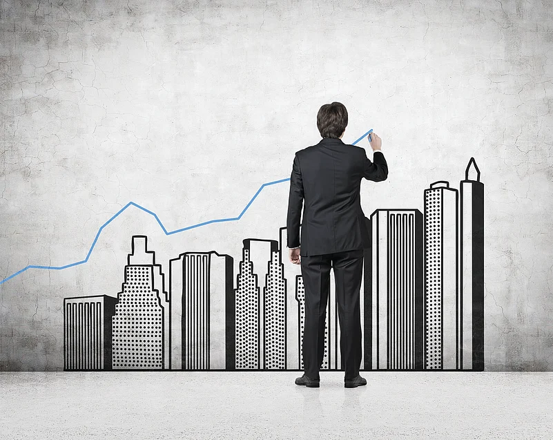 Business leader drawing a growth chart over a city skyline, symbolizing real estate transformation.