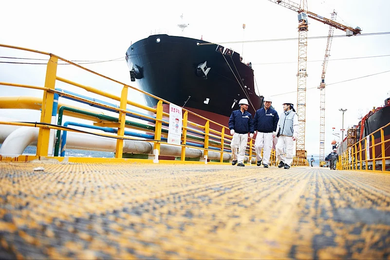 Three men standing near a ship