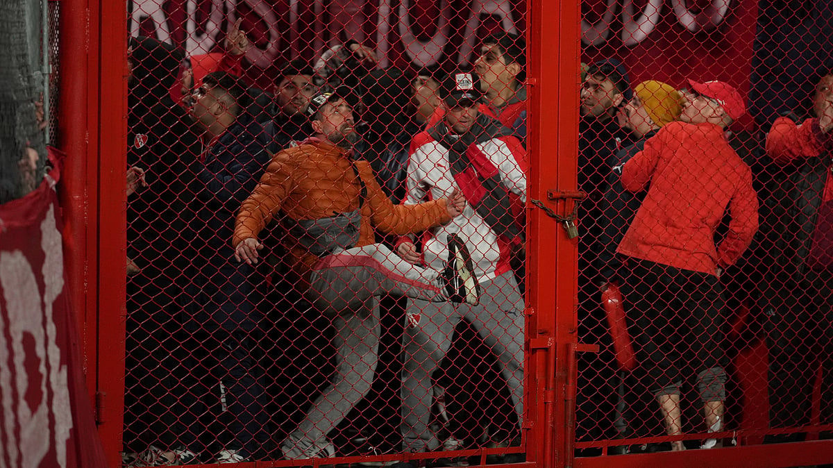 | Photo: AP/Gustavo Garello : Fans of Argentina's Independiente bang on a barrier during a Copa Sudamericana round of sixteen second leg soccer match against Universidad de Chile at the Libertadores de America stadium in Avellaneda, Argentina, Wednesday, Aug. 20, 2025.