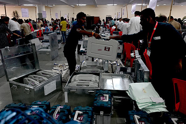 Photo by Bachchan Kumar/Hindustan Times via Getty Images : Election officials carry a (EVM) ballot box for distribution for constituency election scheduled on 20th May 2024 at Agri Koli Bhavan Nerul,, on May 18, 2024 in Navi Mumbai, India. 
