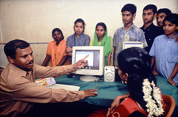 Getty : An instructor trains village teenagers to use of computers under the Akshaya Centre Scheme for the first e-literacy scheme achieved in Malappuram district, Kerala in 2004. 
