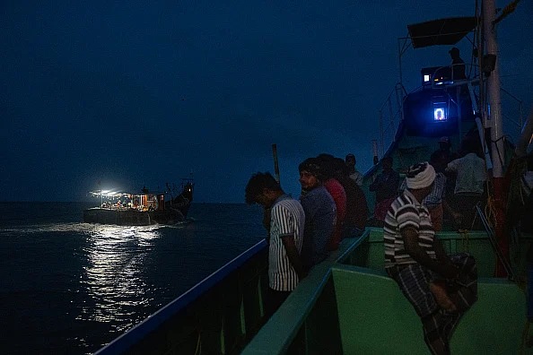 Fishermen sail to the sea at night on August 13, 2025 in Kochi, India.