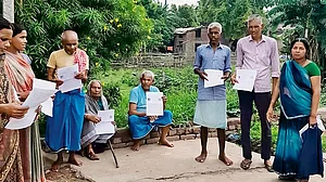 | Getty Images : The Countdown - Villagers hold up enumeration forms distributed in Bihar during the Special Intensive Revision of
electoral rolls