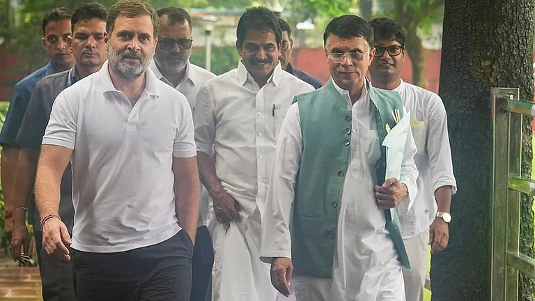 Congress leader Pawan Khera with Rahul Gandhi (L). - Outlook