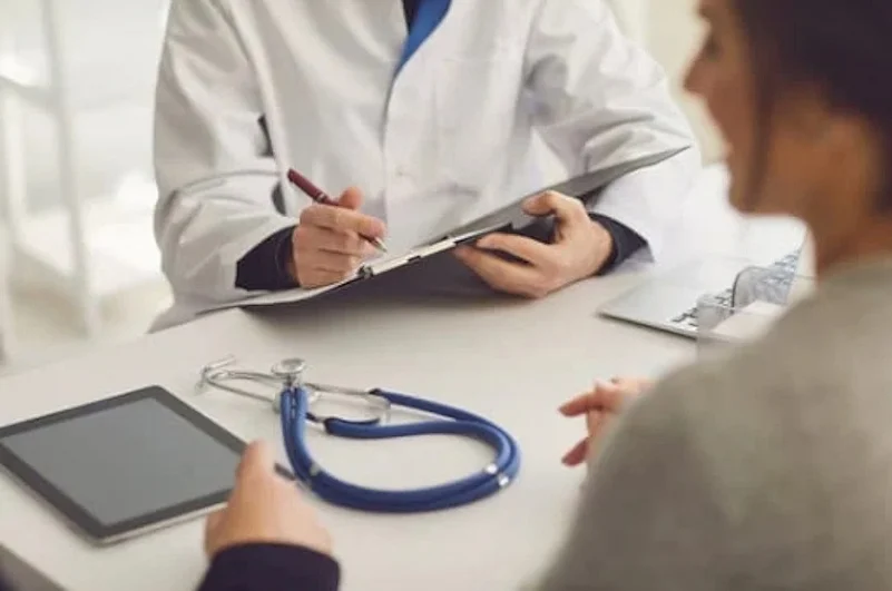 A doctor writing prescription to a patient