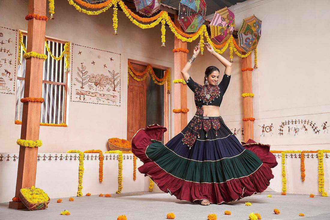 A woman in a indian dress (Chaniya Choli) dancing during a Navratri festival